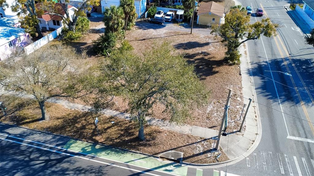 An aerial view shows a vacant, tree-covered corner lot situated between a road and houses — 2762 1ST AVENUE S, ST PETERSBURG, FL