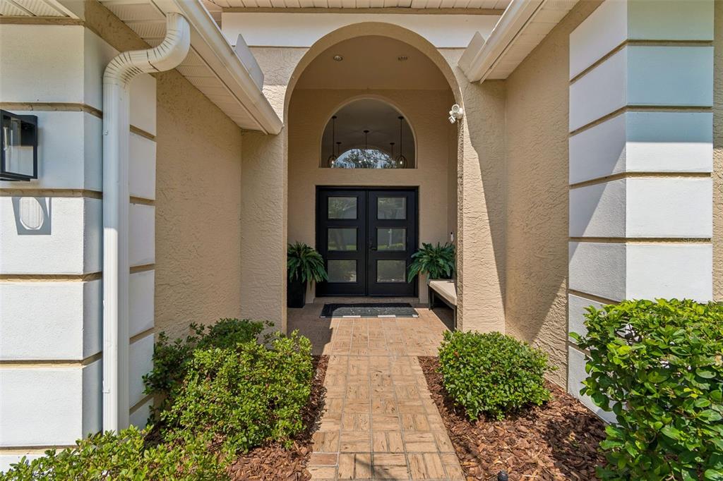 The exterior view shows a front entryway with double glass doors under an arched portico — 17503 EDINBURGH DRIVE, TAMPA, FL
