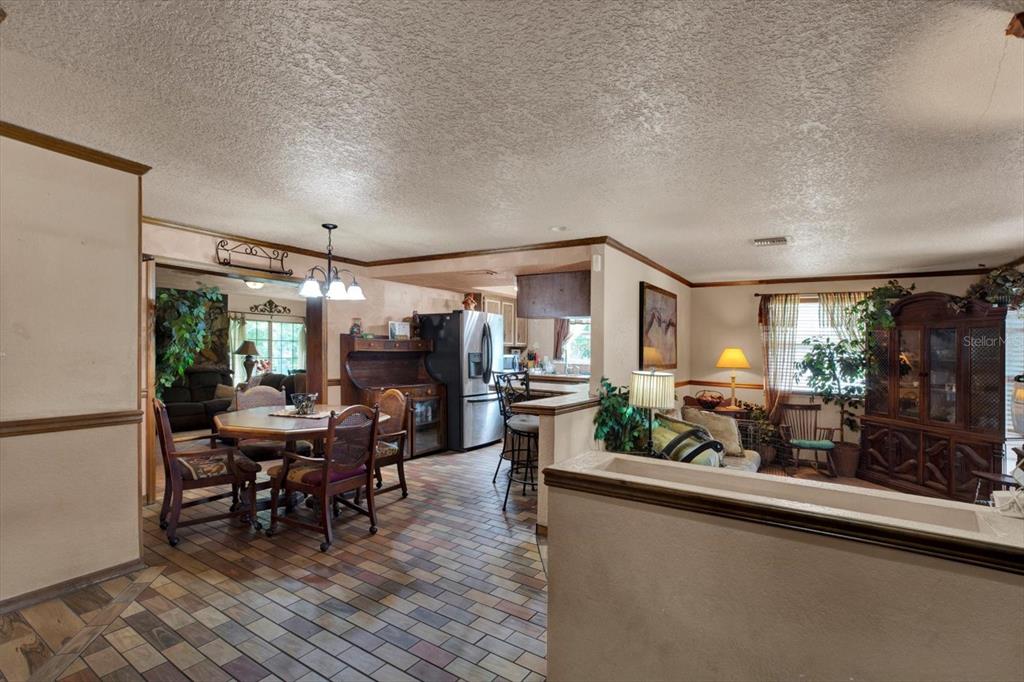A dining area with a brick floor and a kitchen with a breakfast bar — 12030 106TH COURT, LARGO, FL