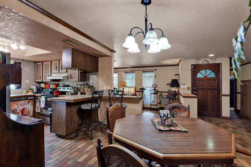 A kitchen and dining area with wood cabinets, a breakfast bar, and a wooden table — 12030 106TH COURT, LARGO, FL