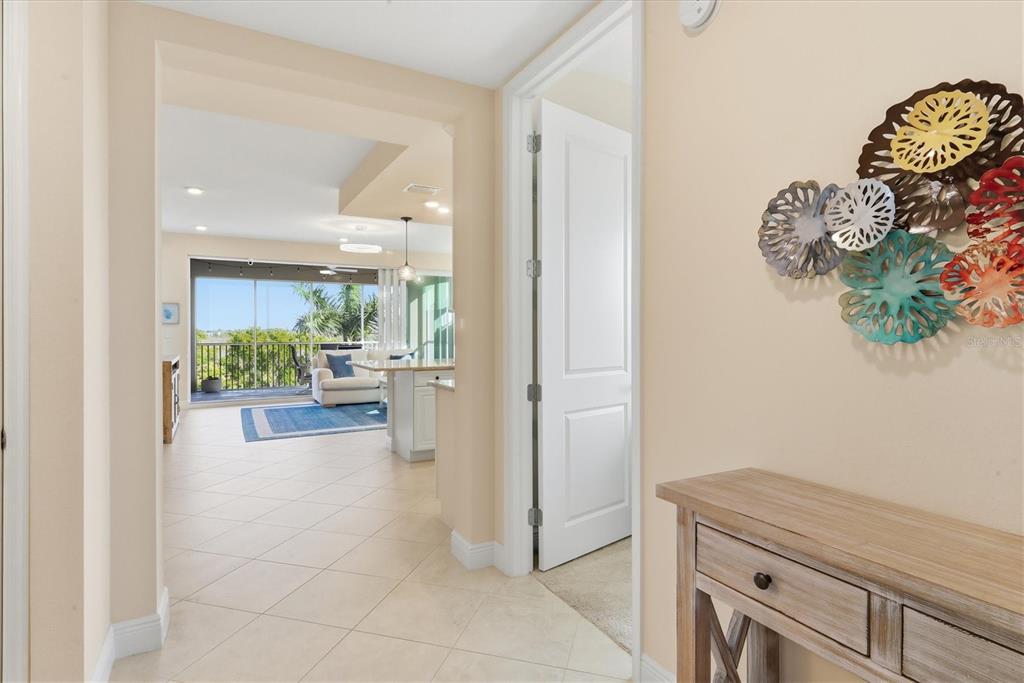 A hallway leads to an open-concept living area with tile floors and a screened balcony — 395 ARUBA CIRCLE UNIT 303, BRADENTON, FL