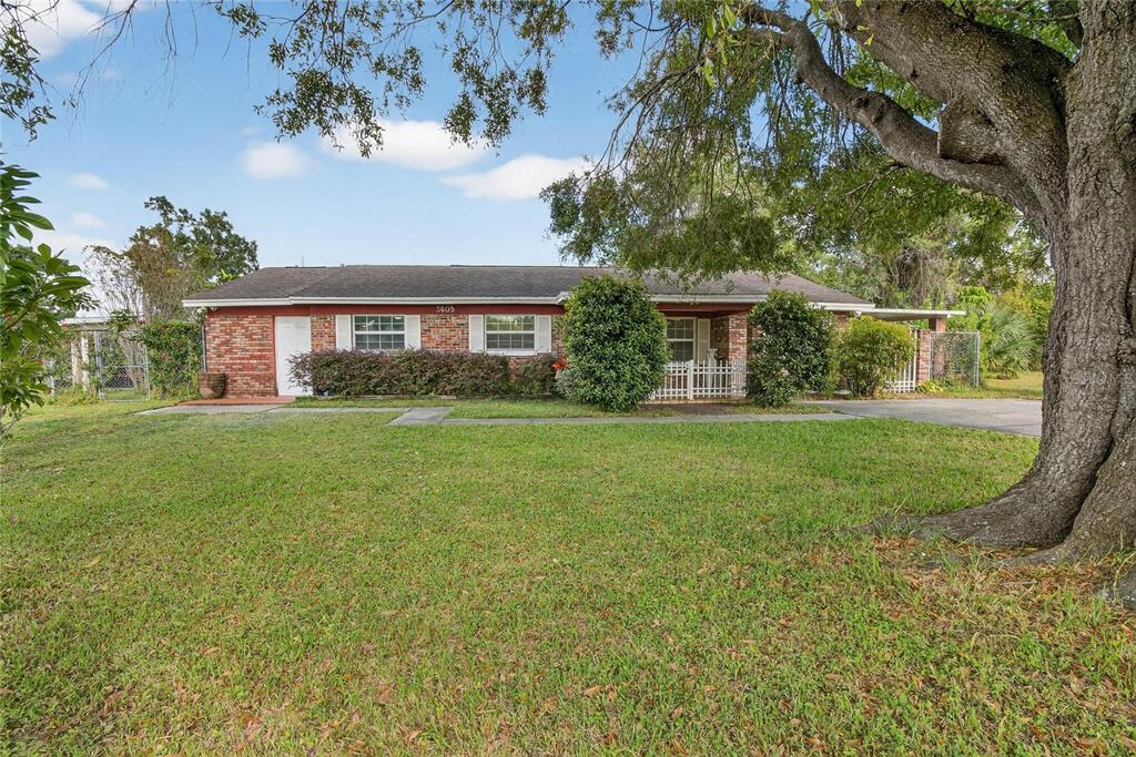 A single-story brick house with a large tree in the front yard — 3605 W FLORA STREET, TAMPA, FL