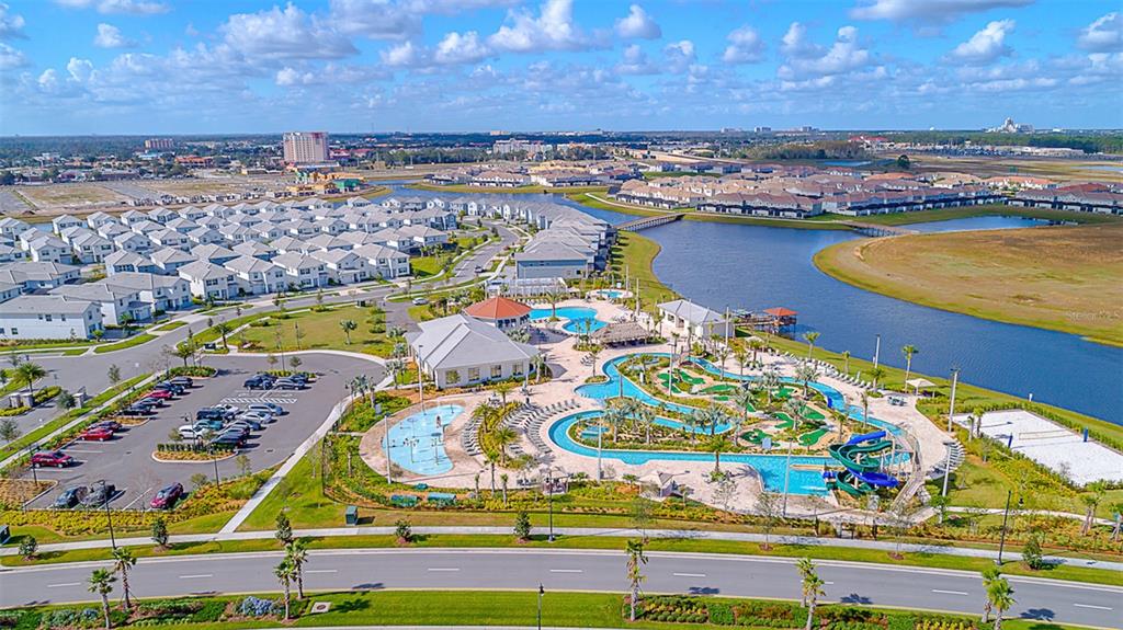 An aerial view shows a residential community with a clubhouse, swimming pools, and water slides — 4156 PARAGRAPH DRIVE, KISSIMMEE, FL