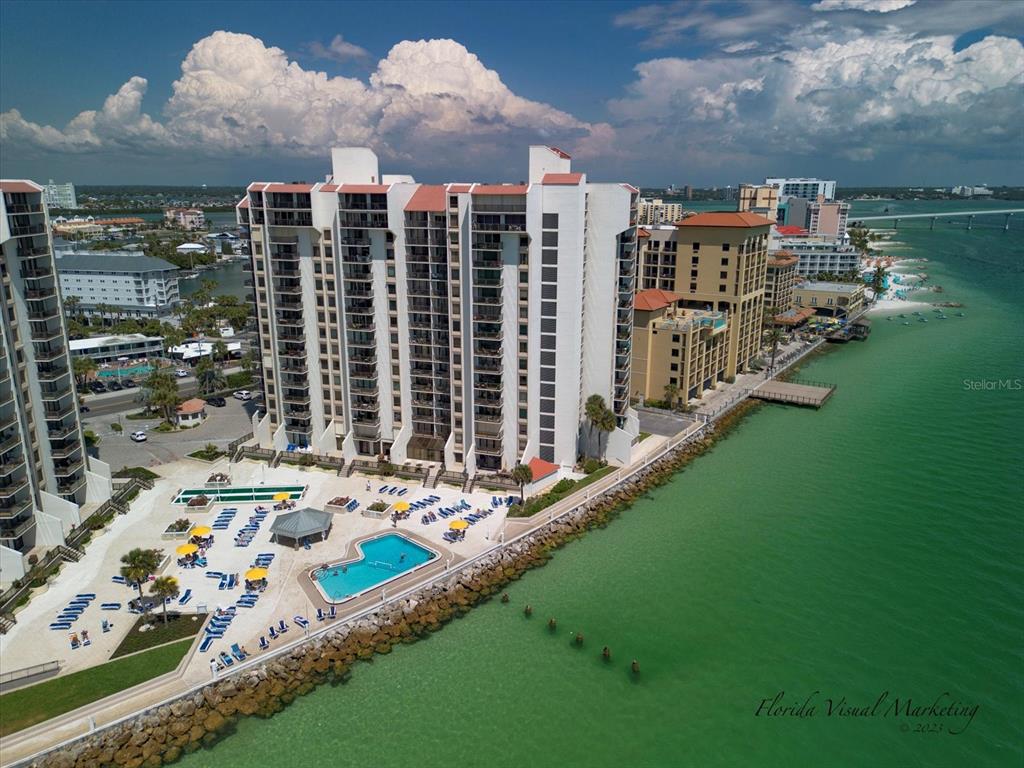 An aerial view of a high-rise condominium complex with a pool overlooking the ocean — 450 S GULFVIEW BOULEVARD UNIT 1204, CLEARWATER, FL