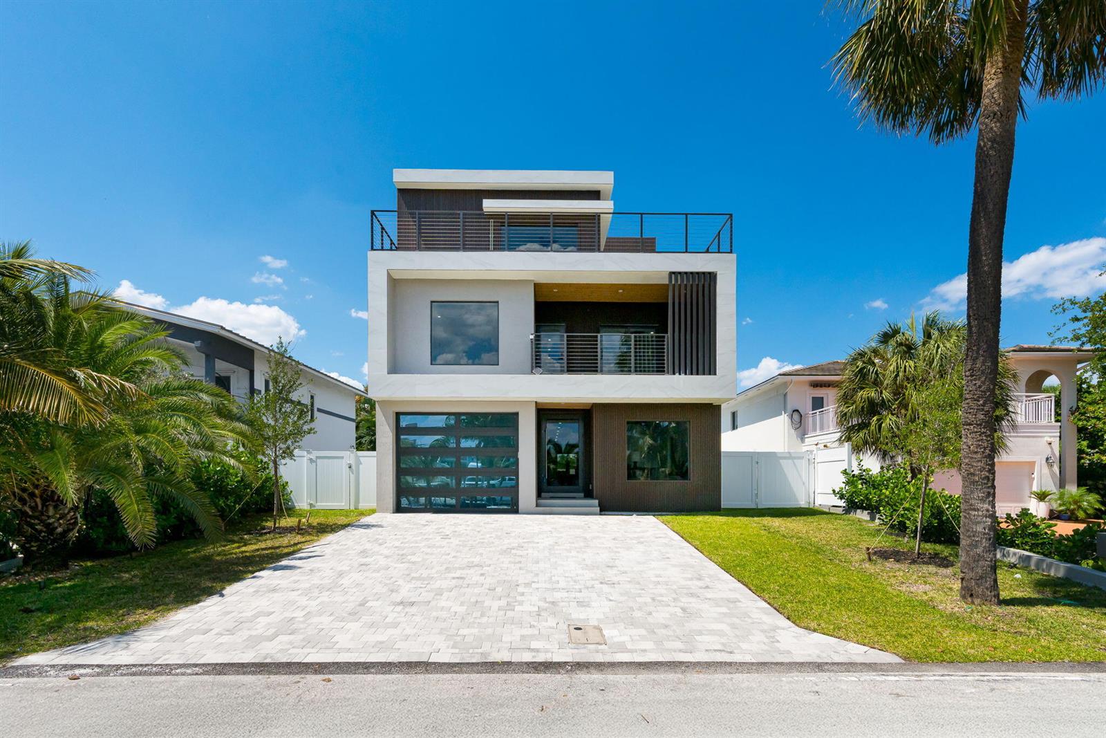 A modern three-story house with a paved driveway, glass garage door, and rooftop balcony — 3225 Canal Drive, Pompano Beach FL 33062, POMPANO BEACH, FL