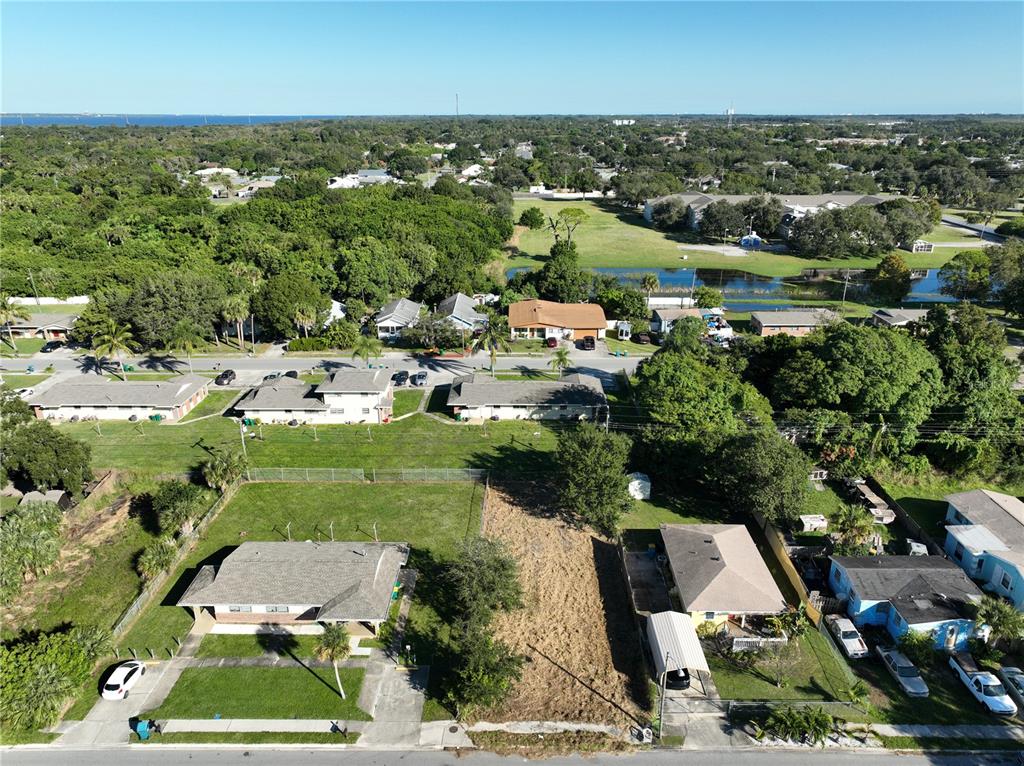 An aerial view shows a vacant lot situated between two residential houses in a neighborhood — 478 ROOSEVELT AVENUE, MERRITT ISLAND, FL
