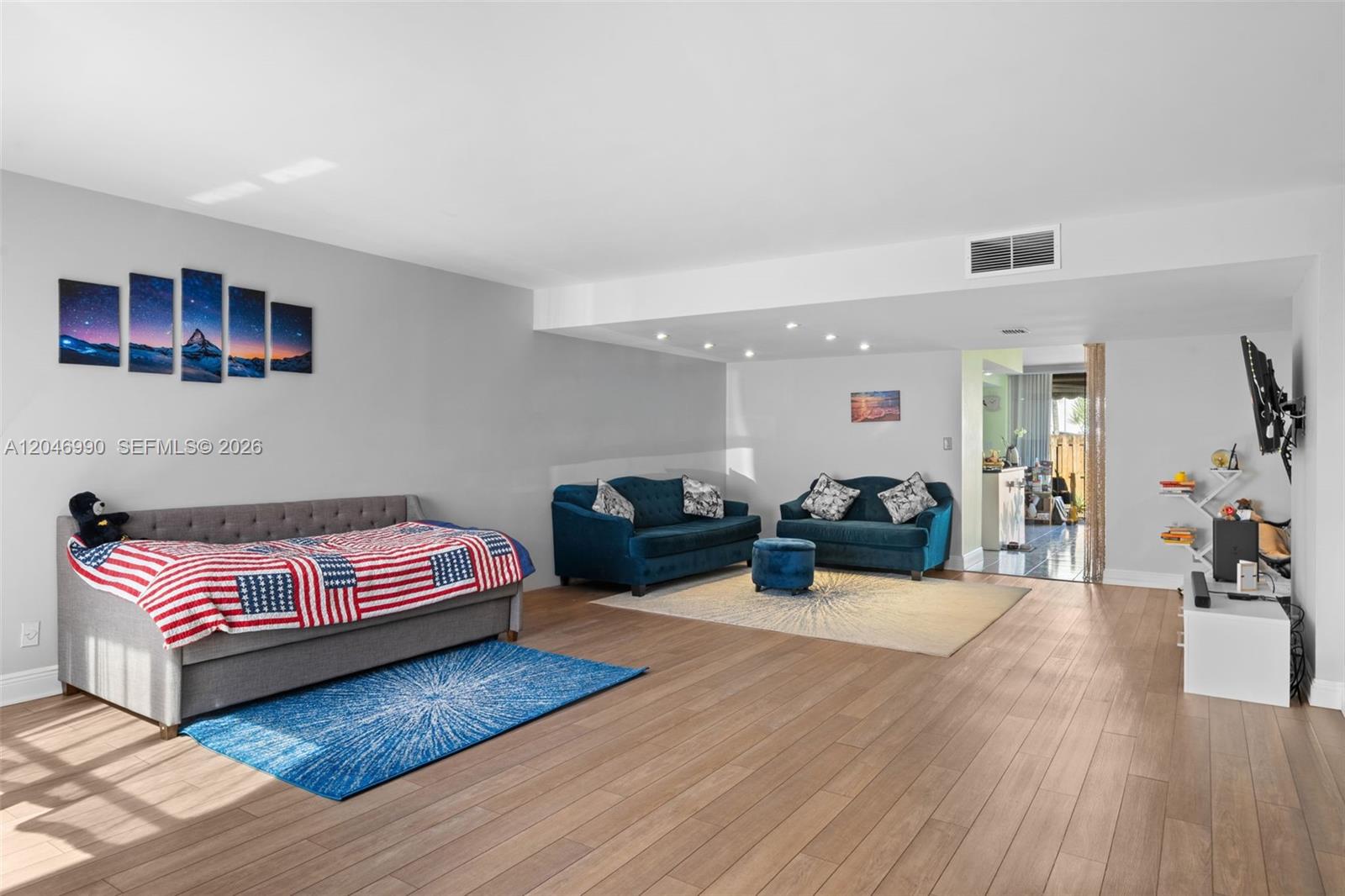A living room features light wood flooring, a gray sofa, and two blue sofas — 801 NE 27th Ave, Hallandale Beach FL 33009, HALLANDALE BEACH, FL