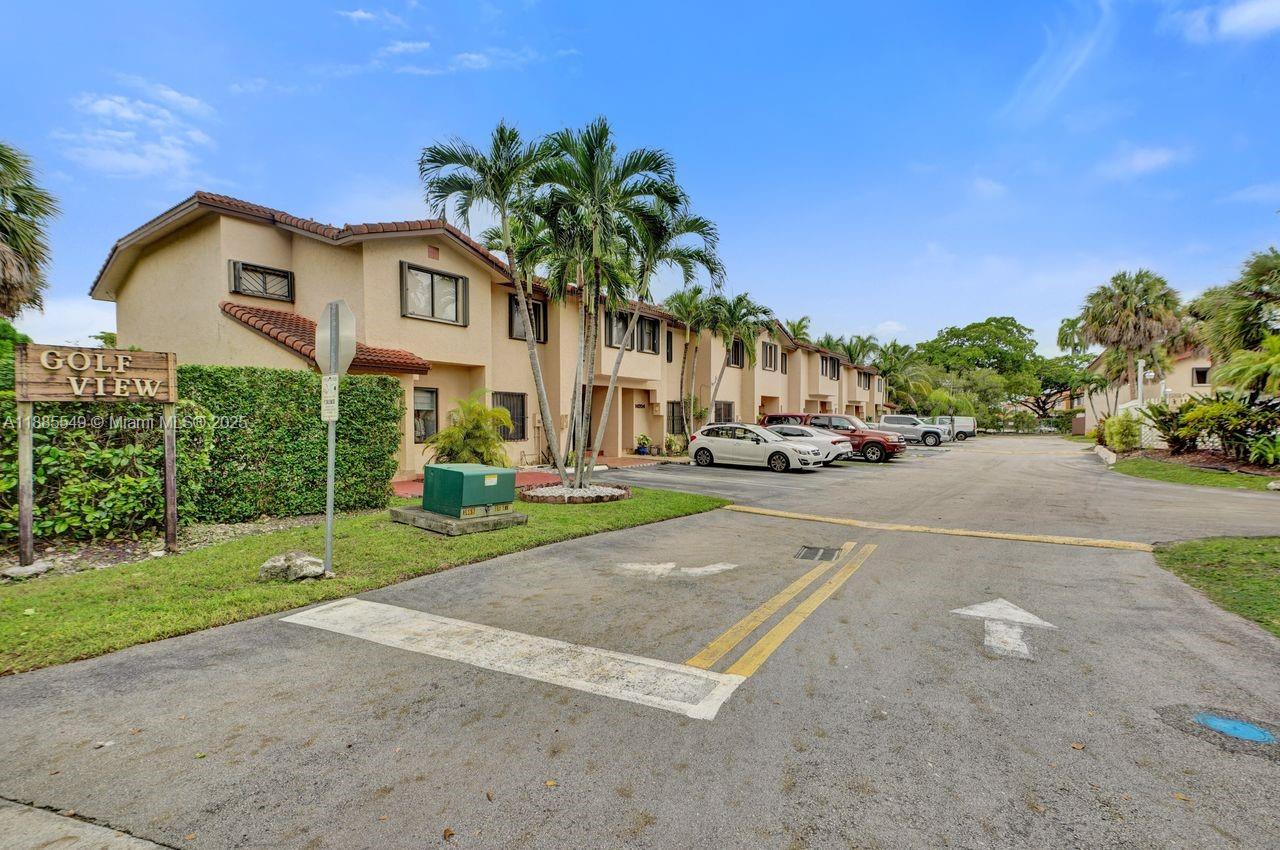 A two-story tan stucco townhouse complex features a parking lot and palm trees — 14201 SW 57th Ln, Miami FL 33183, MIAMI, FL