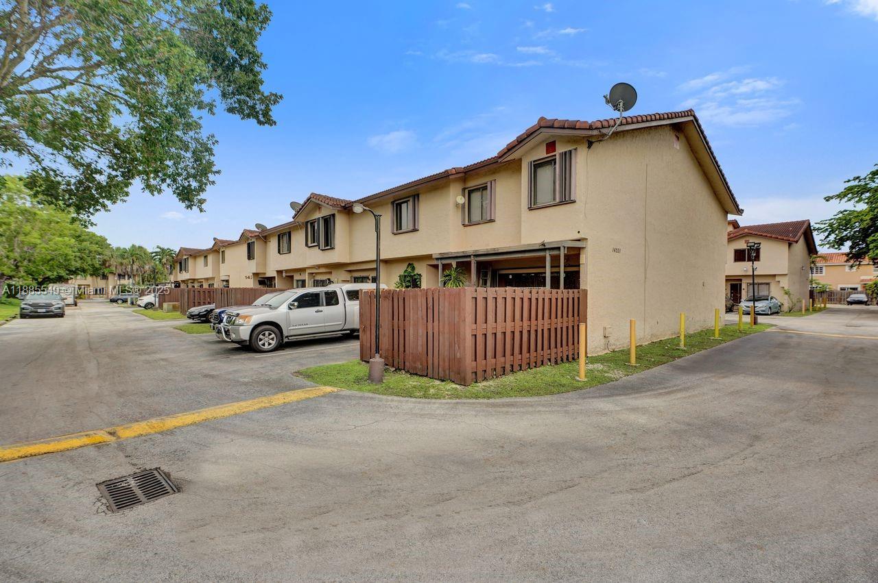 A row of two-story townhouses with tan stucco walls and a wooden privacy fence — 14201 SW 57th Ln, Miami FL 33183, MIAMI, FL