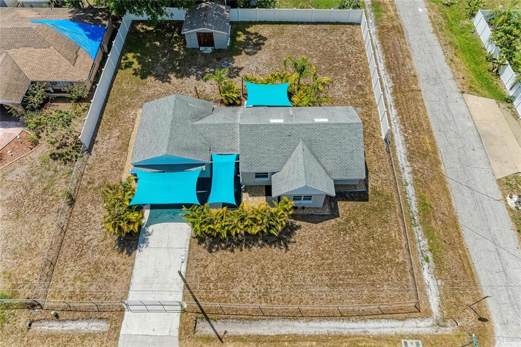 An aerial view shows a house with blue shade sails, a driveway, and a shed — 901 OAK STREET SW, RUSKIN, FL