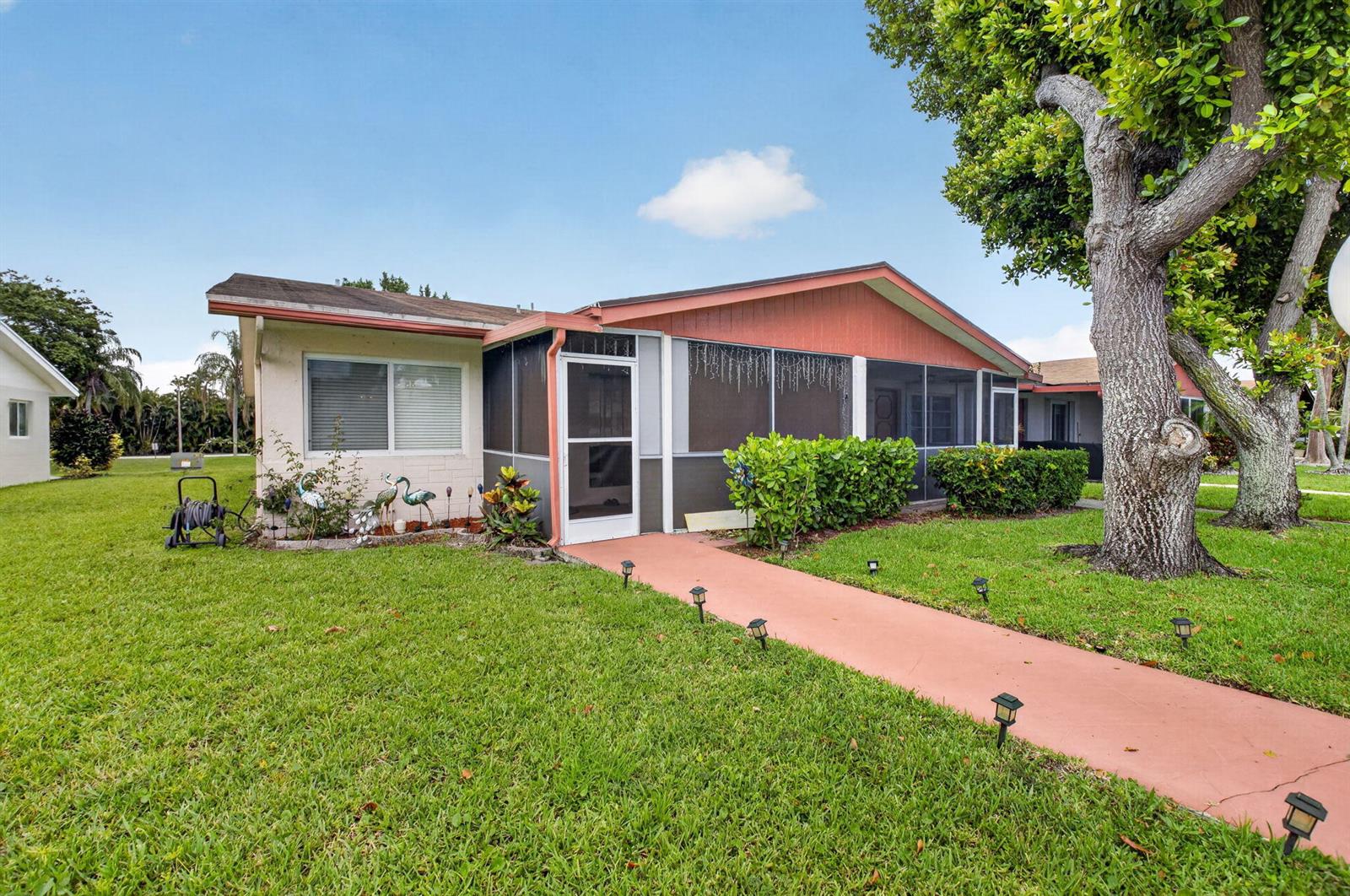 A single-story house with a screened-in porch, a pink walkway, and a large tree — 14232 Campanelli Drive, Delray Beach FL 33484, DELRAY BEACH, FL