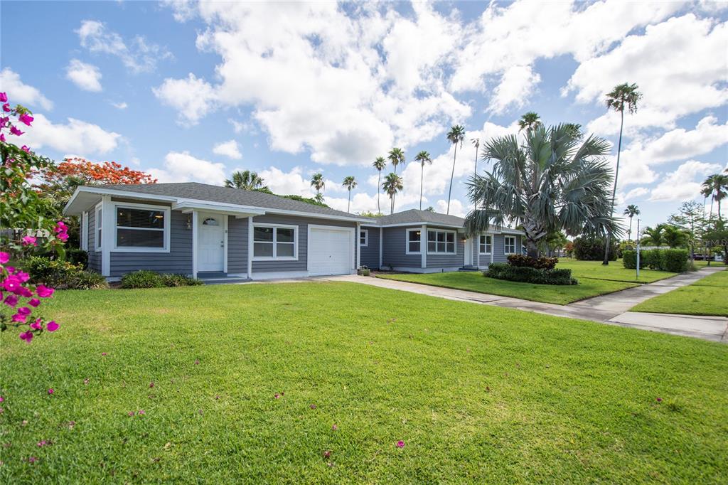 A gray, single-story house with a white garage door and a green lawn — 3200 W DE BAZAN AVENUE, ST PETE BEACH, FL