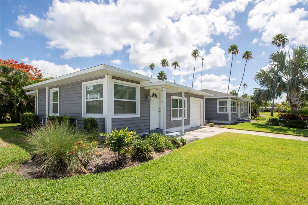 A gray, single-story house with a white door and garage sits on a grassy lawn — 3200 W DE BAZAN AVENUE, ST PETE BEACH, FL