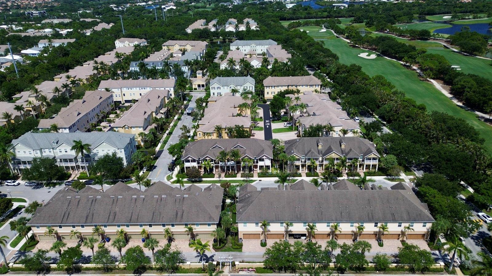 An aerial view shows multiple rows of multi-story townhomes with beige siding and gray roofs — 118 Black Ironwood Road # 107, Jupiter FL 33458, JUPITER, FL