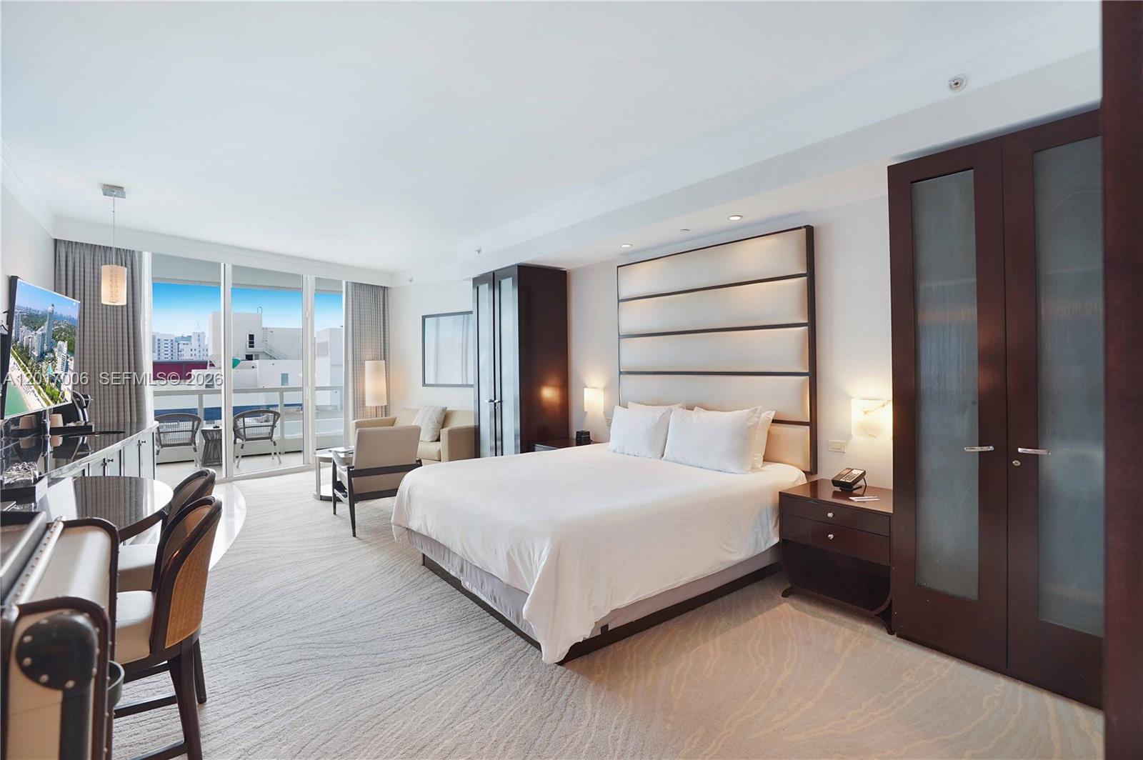 A hotel-style bedroom features a king bed, a seating area, and a balcony with views — 4391 Collins Ave # 916, Miami Beach FL 33140, MIAMI BEACH, FL