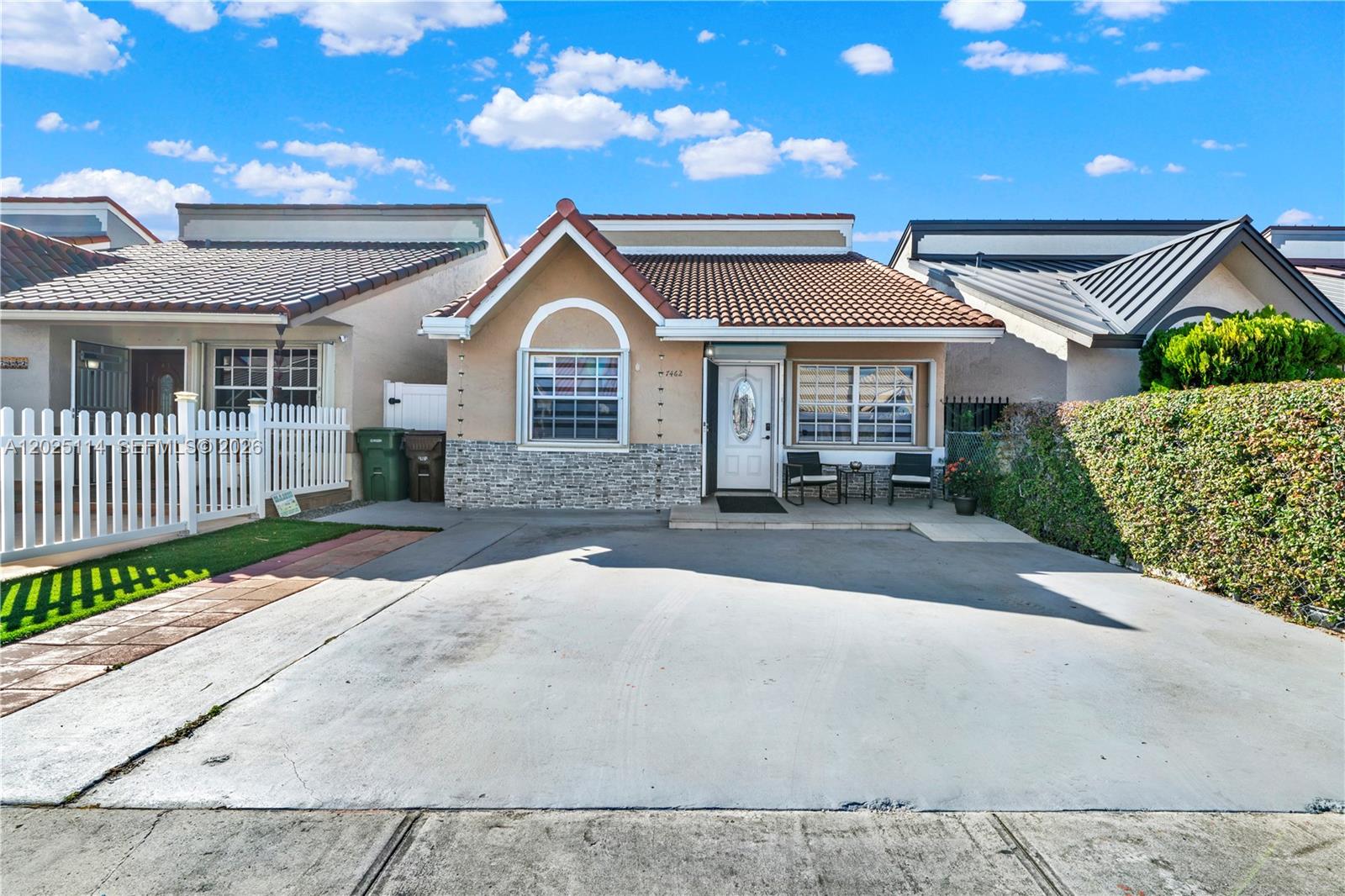 A single-story house with a concrete driveway, stone facade, and a tiled roof — 7462 W 29th Way, Hialeah FL 33018, HIALEAH, FL