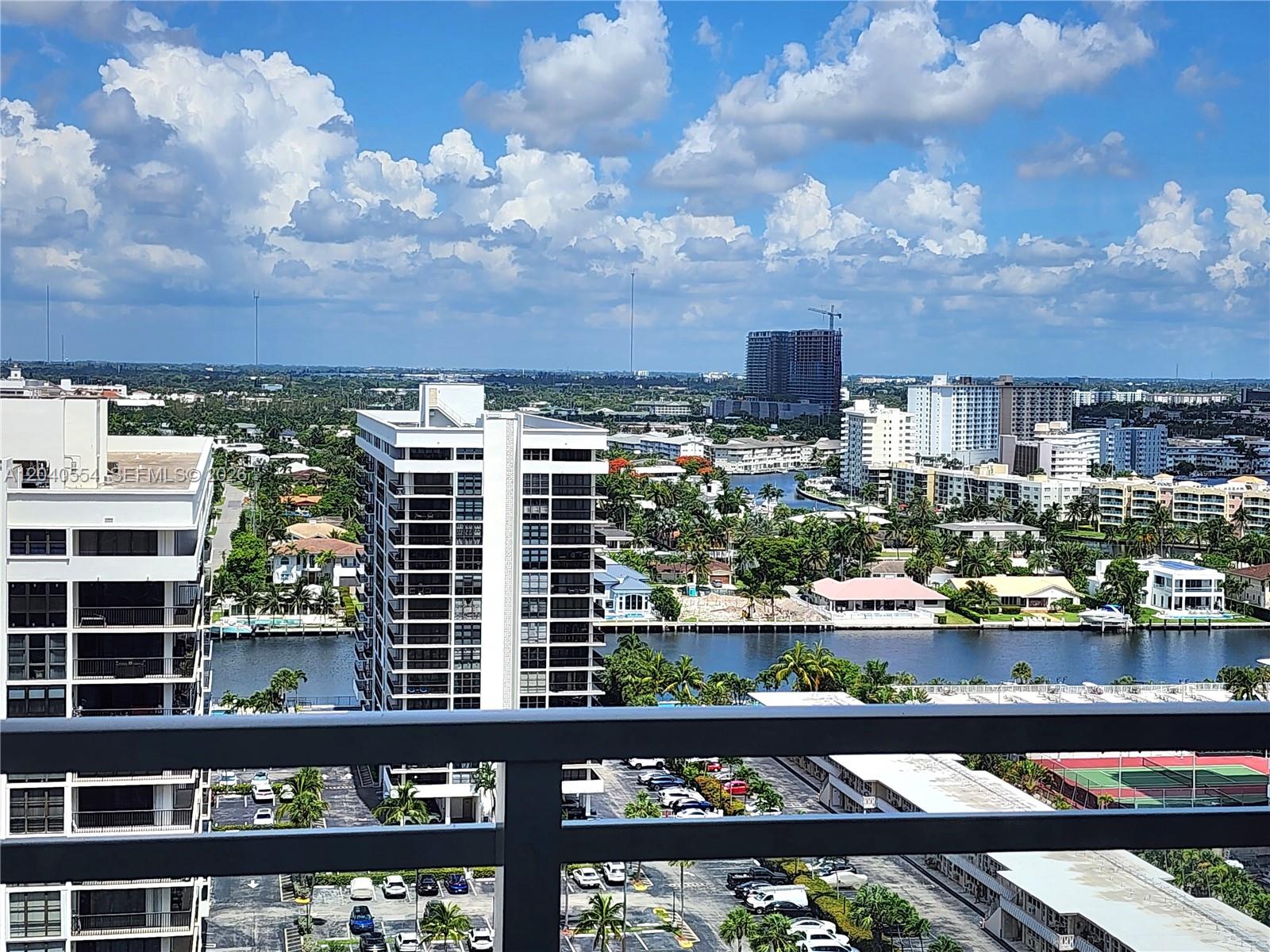 An elevated view shows a canal, residential buildings, and a parking lot under a cloudy sky — 2030 S Ocean Dr # 1803, Hallandale Beach FL 33009, HALLANDALE BEACH, FL