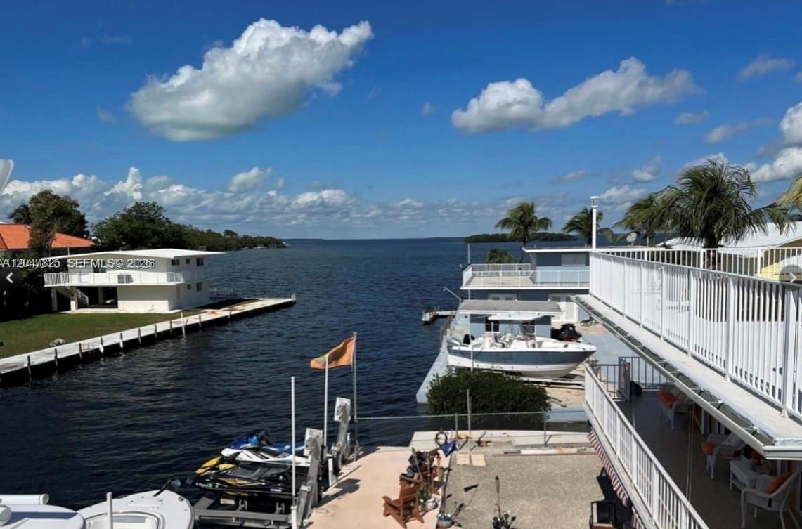 An elevated view of a waterfront property featuring a boat dock, jet skis, and ocean — 235 Anne Bonny Dr, Key Largo FL 33034, KEY LARGO, FL