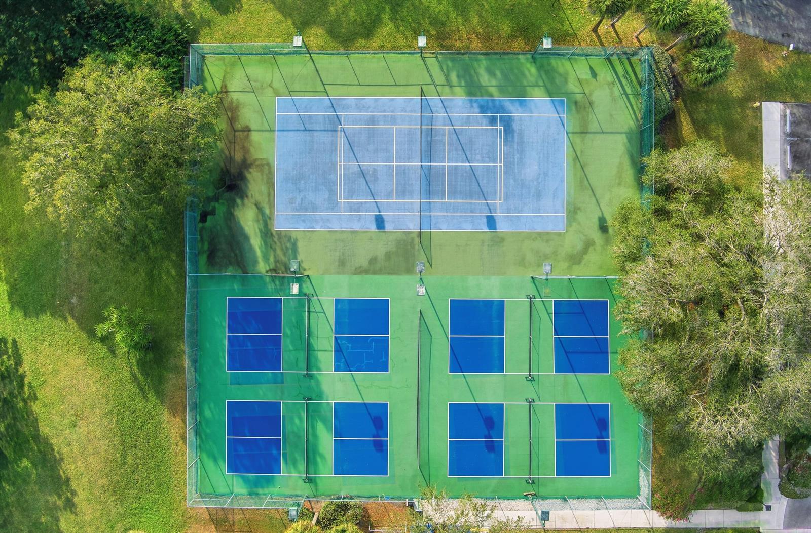 An aerial view shows a fenced recreational area with one tennis court and four pickleball courts — 6100 SE Martinique Drive # 201, Stuart FL 34997, STUART, FL