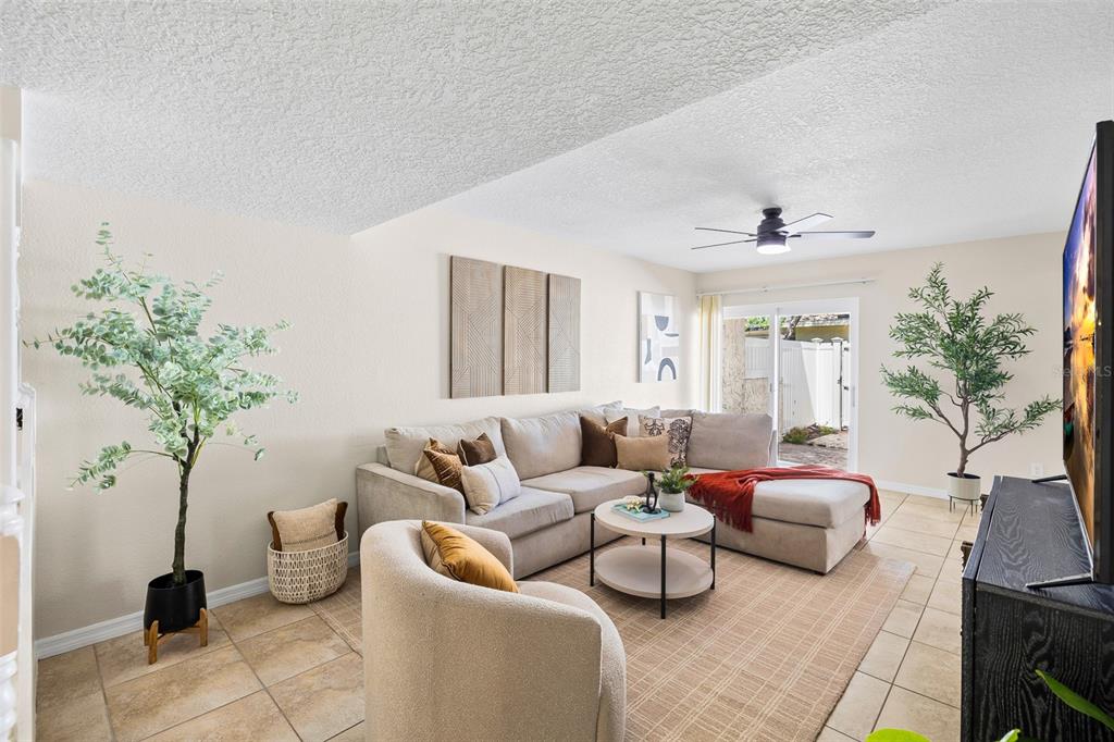 A patio features a brick floor, a fire pit, outdoor seating, and a white fence — 7256 MOFFATT LANE N, PINELLAS PARK, FL