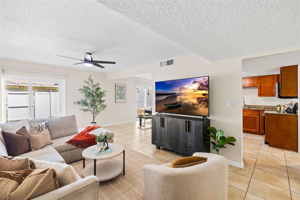 A living room features a sectional sofa, an armchair, a coffee table, and tiled floors — 7256 MOFFATT LANE N, PINELLAS PARK, FL