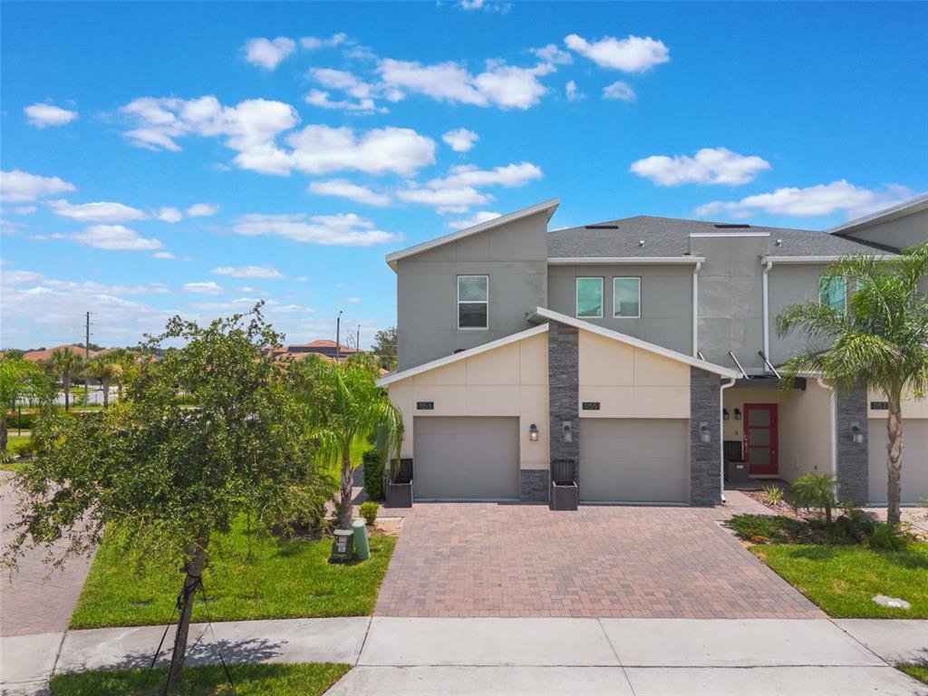 An exterior view of a two-story townhouse with two garage doors and a paved driveway — 1153 DROP LANE, DAVENPORT, FL