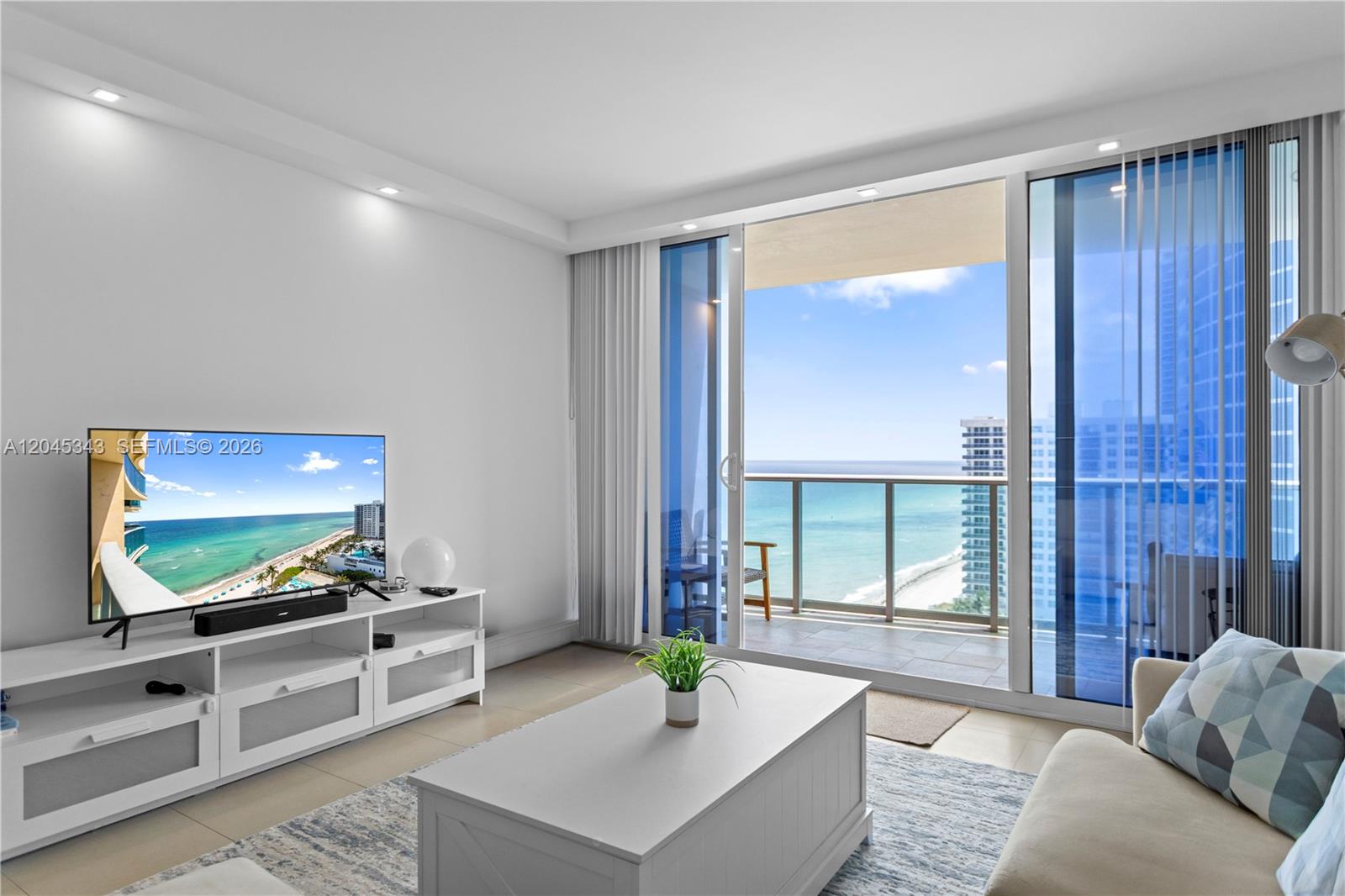 A living room features a white media console, a coffee table, and a balcony view — 2501 S Ocean Dr # 1614, Hollywood FL 33019, HOLLYWOOD, FL