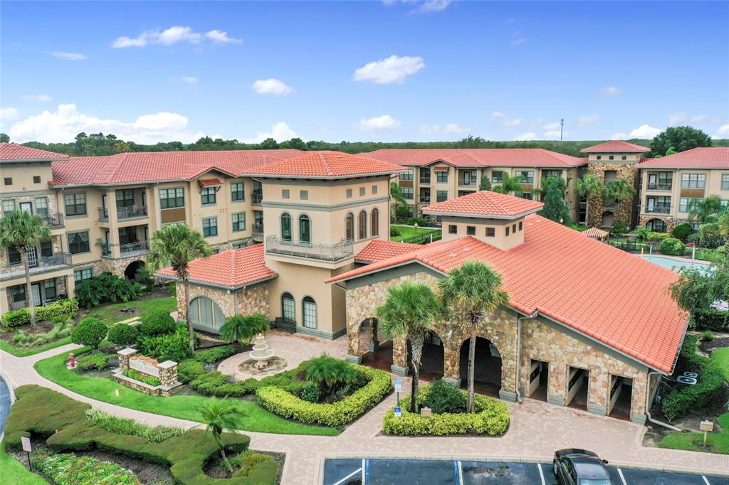 An aerial view of a multi-story apartment complex with terracotta roofs and stone exterior accents — 901 CHARO PARKWAY UNIT 732, DAVENPORT, FL