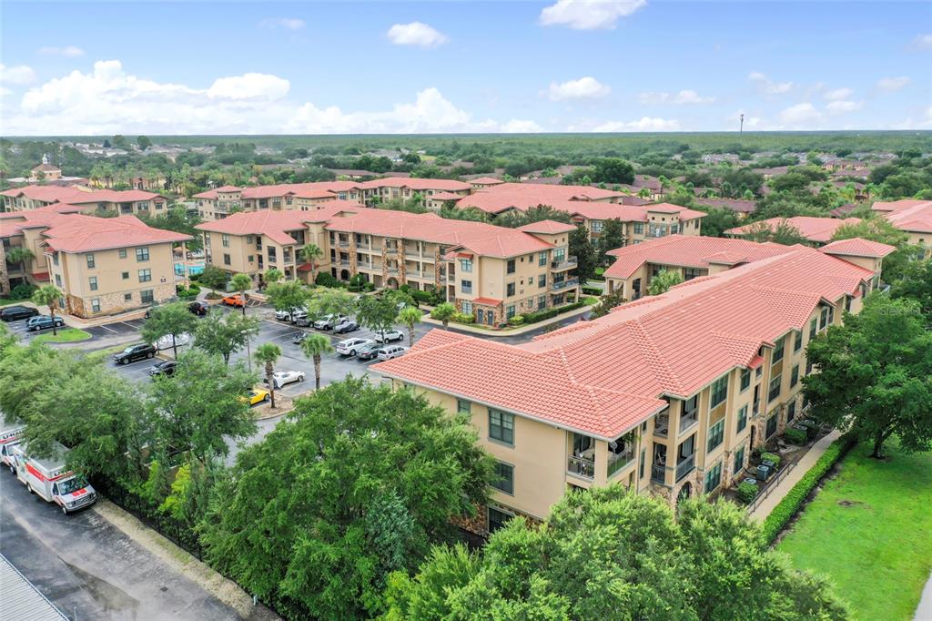 An aerial view shows multi-story apartment buildings with red tile roofs and a parking lot — 901 CHARO PARKWAY UNIT 732, DAVENPORT, FL