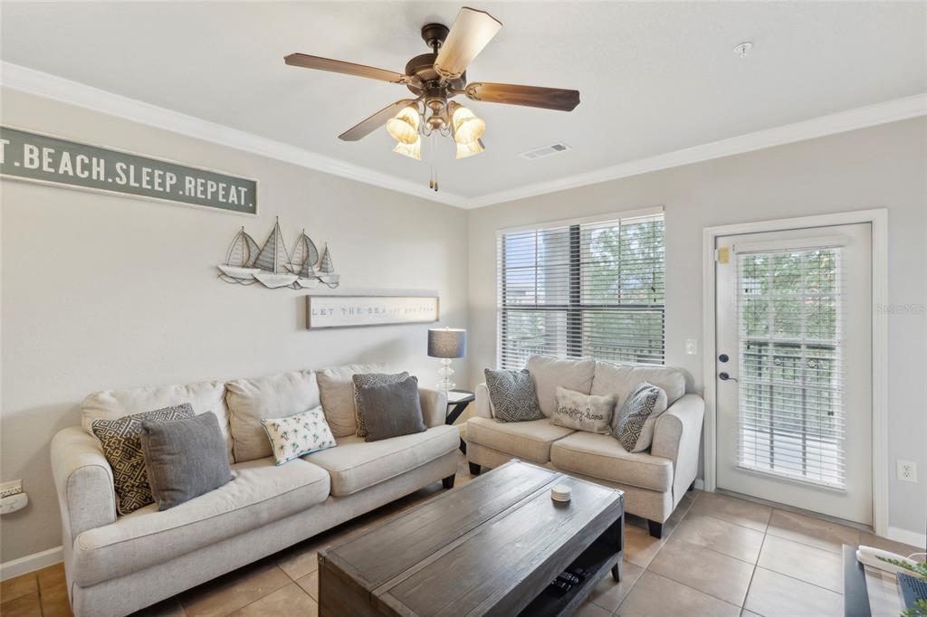 A living room features two beige sofas, a wooden coffee table, and a ceiling fan — 901 CHARO PARKWAY UNIT 732, DAVENPORT, FL
