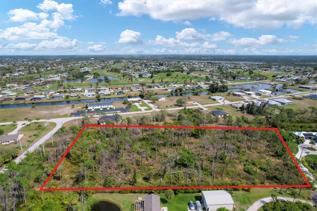 An aerial view shows a large, rectangular, wooded vacant lot outlined in red — 9232 SPRING VALLEY ROAD, ENGLEWOOD, FL