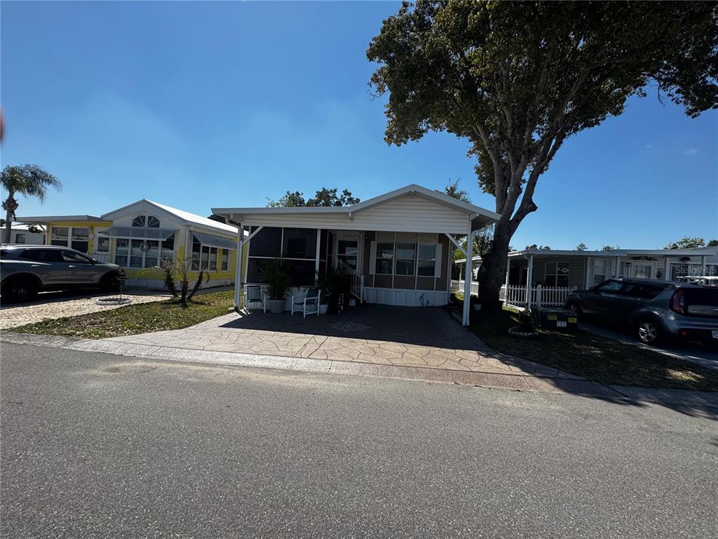 A single-story manufactured home with a covered carport and a paved driveway — 123 PANSY STREET, DAVENPORT, FL