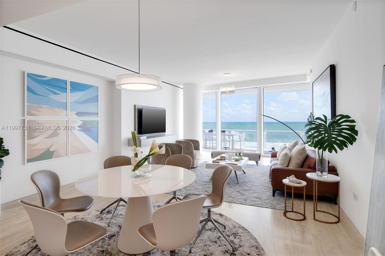 A modern living and dining area features floor-to-ceiling windows with an ocean view — 9001 Collins Ave # 605, Surfside FL 33154, SURFSIDE, FL