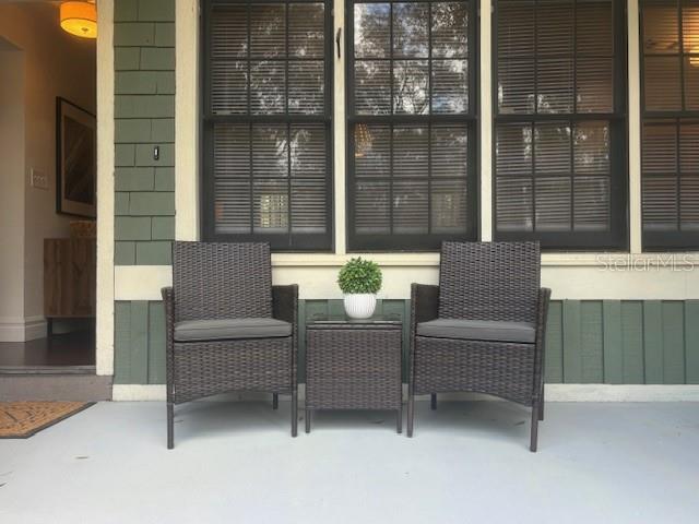 Two dark wicker chairs and a small table sit on a covered porch — 5319 SW 88TH COURT, GAINESVILLE, FL