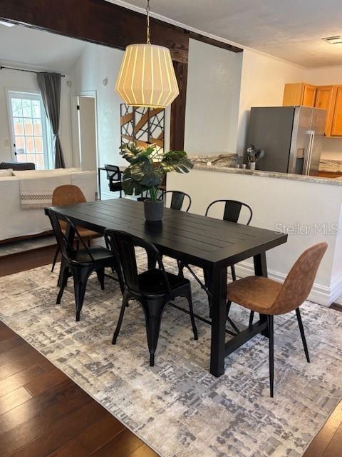 A dining area features a black table, mixed chairs, and a pendant light on a rug — 5319 SW 88TH COURT, GAINESVILLE, FL