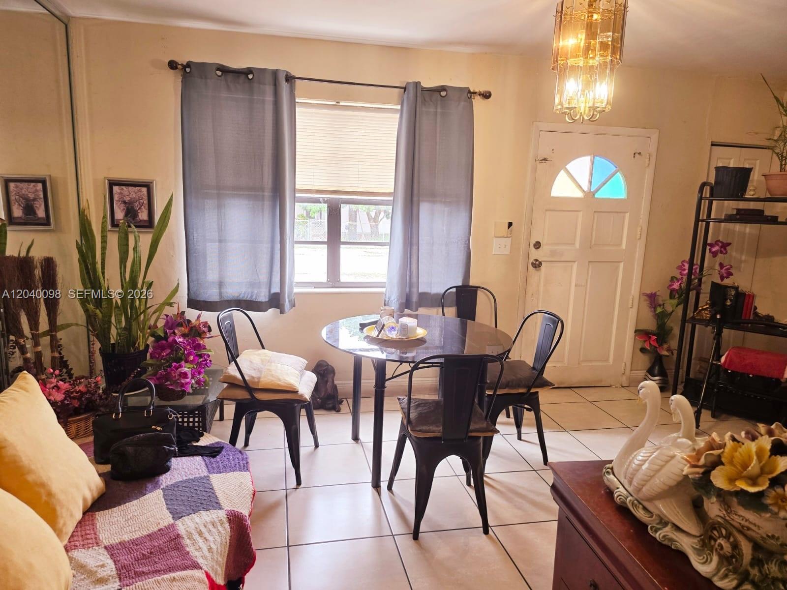 A dining area features a round glass table, four metal chairs, and a tiled floor — 4074 NW 4th St, Miami FL 33126, MIAMI, FL