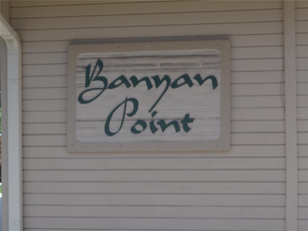 A rectangular sign reading Banyan Point is mounted on a light-colored horizontal siding wall — 601 SHREVE STREET UNIT 41C, PUNTA GORDA, FL