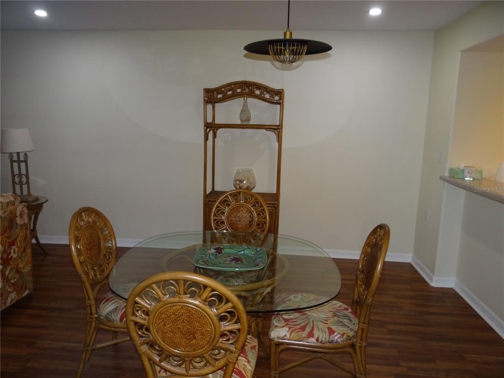A dining area features a glass-topped rattan table, four matching chairs, and a tall hutch — 601 SHREVE STREET UNIT 41C, PUNTA GORDA, FL