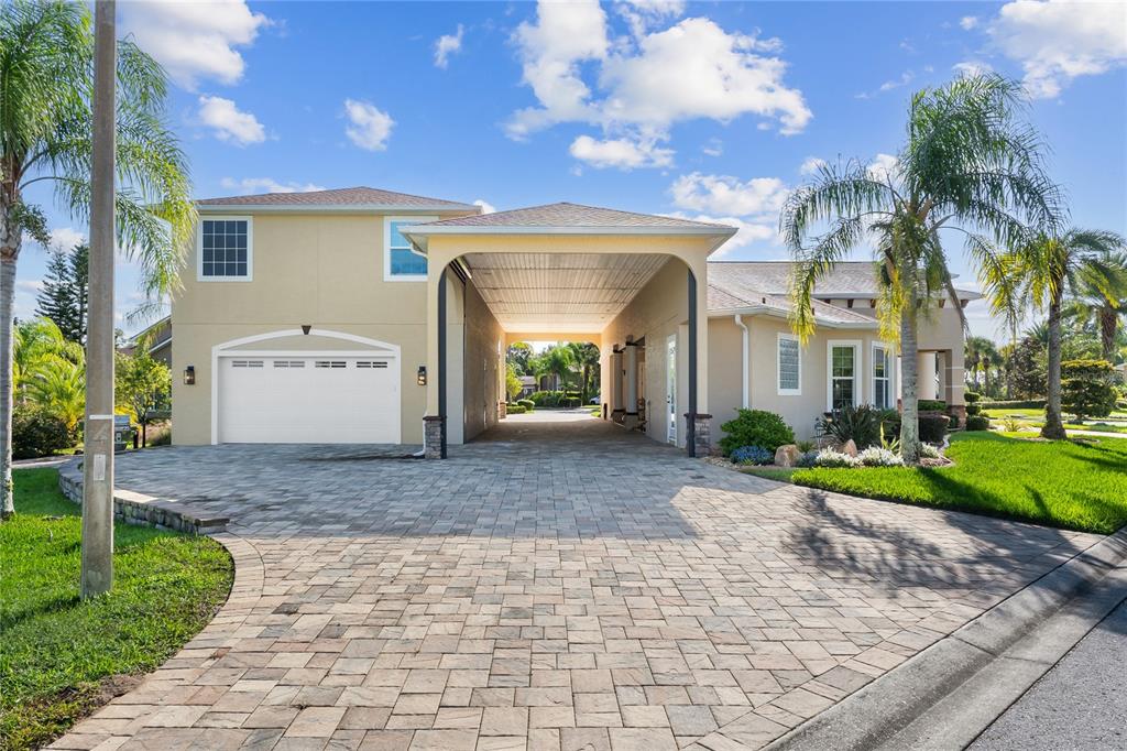A two-story house features a paved driveway leading to a garage and a covered porte-cochère — 398 NOLANE LANE, POLK CITY, FL