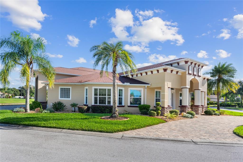 A single-story house with a tan stucco exterior, a tiled roof, and a paved driveway — 398 NOLANE LANE, POLK CITY, FL