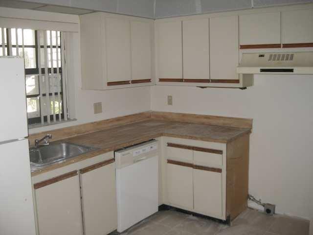 A kitchen features off-white cabinets with wood trim, laminate countertops, and a white dishwasher — 3665 NW 94th Avenue # 3j, Sunrise FL 33351, SUNRISE, FL
