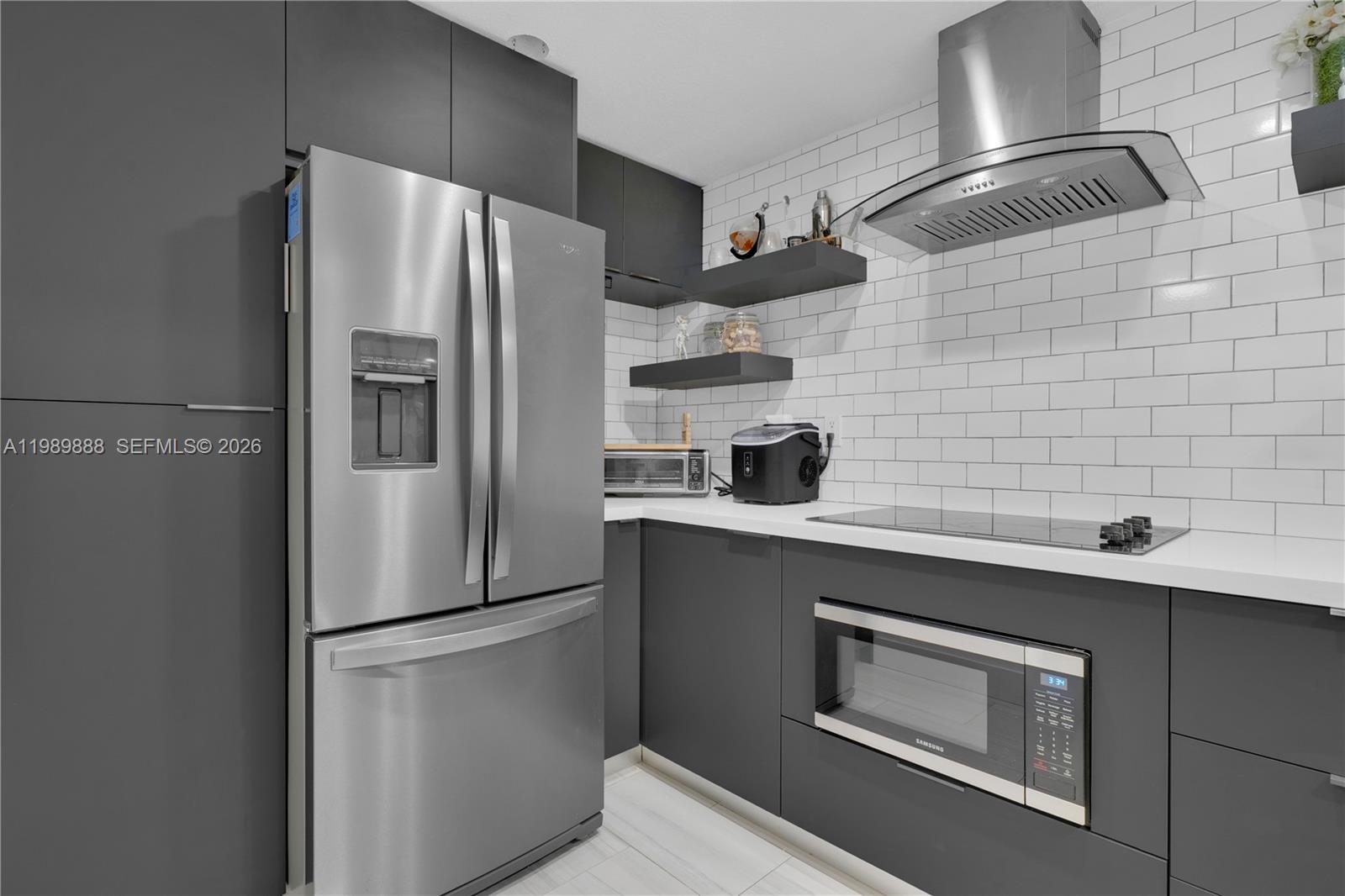 A modern kitchen features dark gray cabinetry, stainless steel appliances, and white subway tile backsplash — 9956 SW 88th St # 1, Miami FL 33176, MIAMI, FL