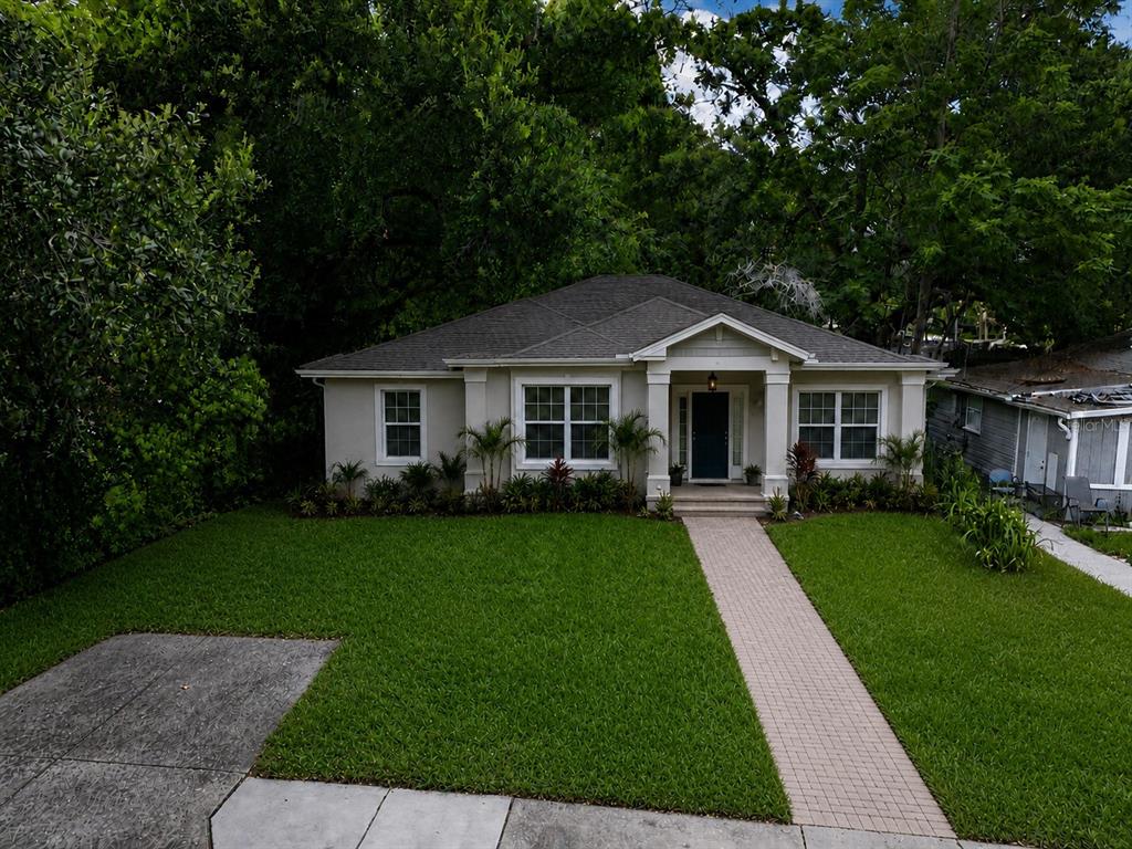 A single-story house with a gray roof, light siding, and a paved walkway to the entrance — 1413 29TH STREET, ORLANDO, FL