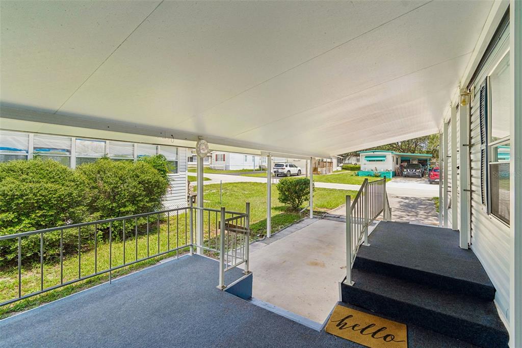 A covered carport and front porch with steps leading to a home entrance — 34992 FRASER STREET, DADE CITY, FL