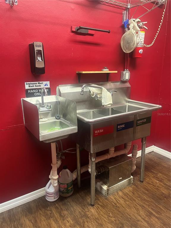 A commercial kitchen area features a stainless steel three-compartment sink and a separate hand-washing sink — 334 N DONNELLY STREET, MOUNT DORA, FL