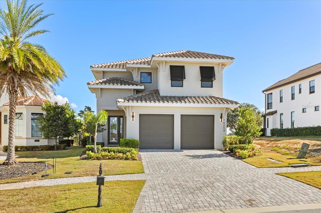 A two-story house with a tiled roof, two-car garage, and a paved driveway — 16254 RAVENNA COURT, MONTVERDE, FL