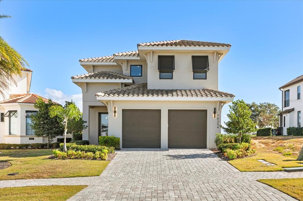 A two-story house with a two-car garage and a paved driveway under a clear sky — 16254 RAVENNA COURT, MONTVERDE, FL