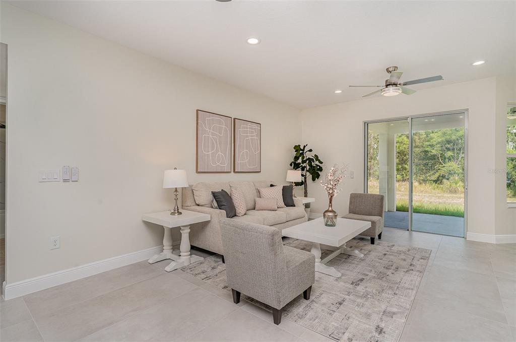 A living room features a beige sofa, two armchairs, a coffee table, and sliding glass doors — 296 DELAKE ROAD NW, PALM BAY, FL