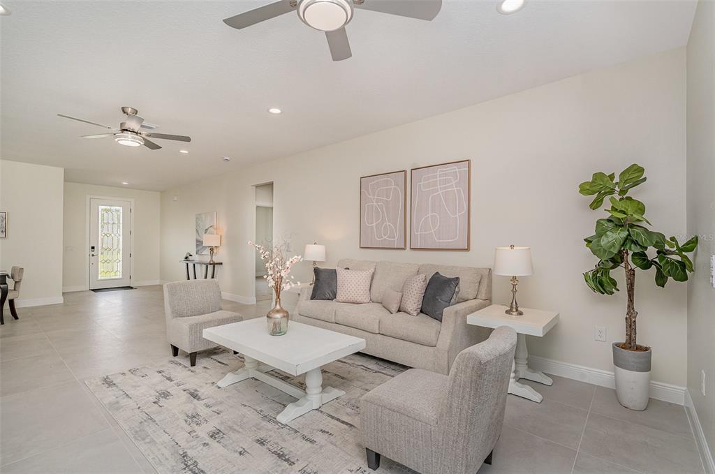 A living room features a beige sofa, two armchairs, a coffee table, and a potted plant — 296 DELAKE ROAD NW, PALM BAY, FL