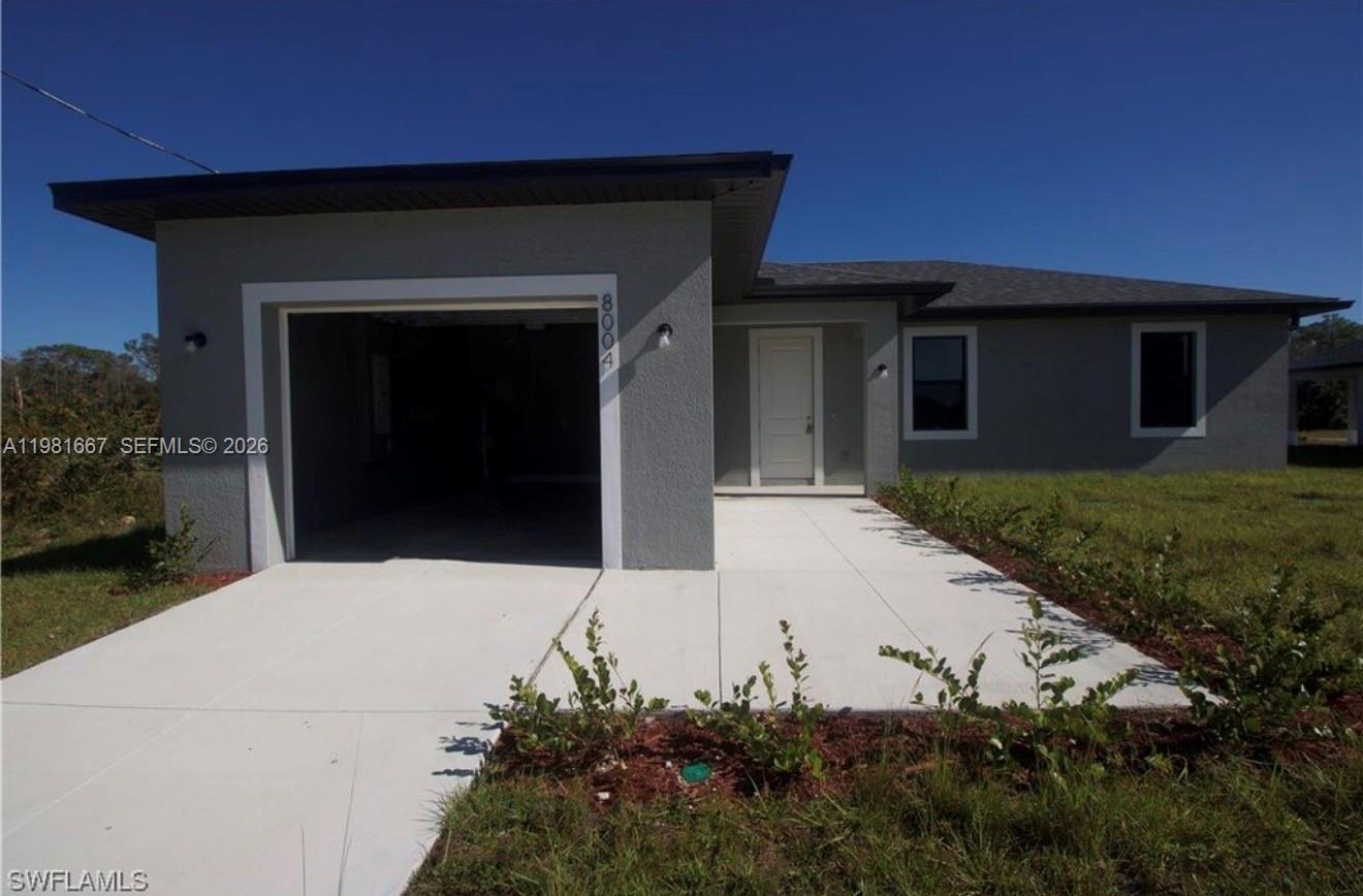 A single-story house with a gray stucco exterior, a one-car garage, and a concrete driveway — 8004 Spice CT, La Belle FL 33935, LA BELLE, FL